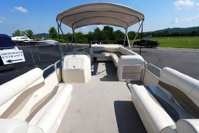 Slide: The Image of 2007 Godfrey 200 Sweetwater pontoon boat with canopy, spacious seating, and showroom entrance sign. - 8