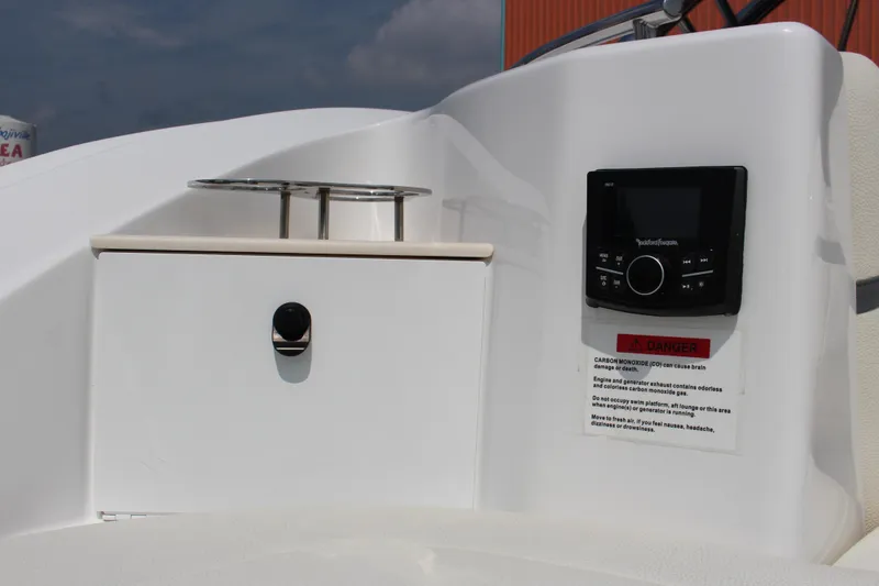 Slide: The Image of Control panel and storage on 2018 Cobalt R35 boat, featuring audio system and safety warning. - 19