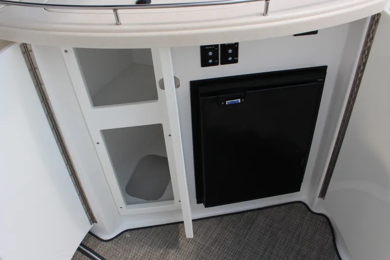 Slide: The Image of 2018 Cobalt R35 boat interior with storage compartments and a compact refrigerator. - 27