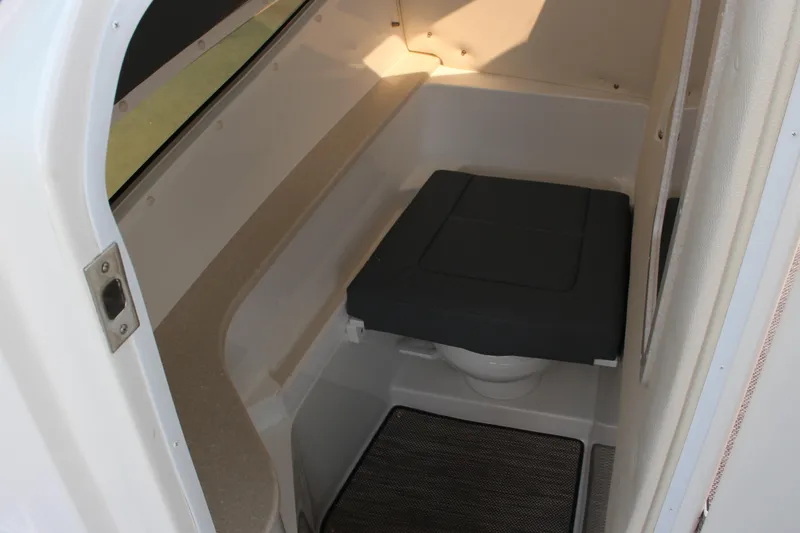 Slide: The Image of 2018 Cobalt R35 boat interior with compact marine toilet and cushioned seat. - 37