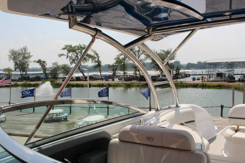 Slide: The Image of 2018 Cobalt R35 boat docked by a scenic waterfront with flags and trees. - 43