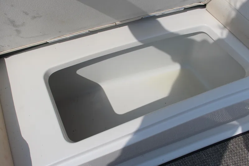 Slide: The Image of Open storage compartment in 2018 Cobalt R35 boat, featuring a clean, white interior. - 48