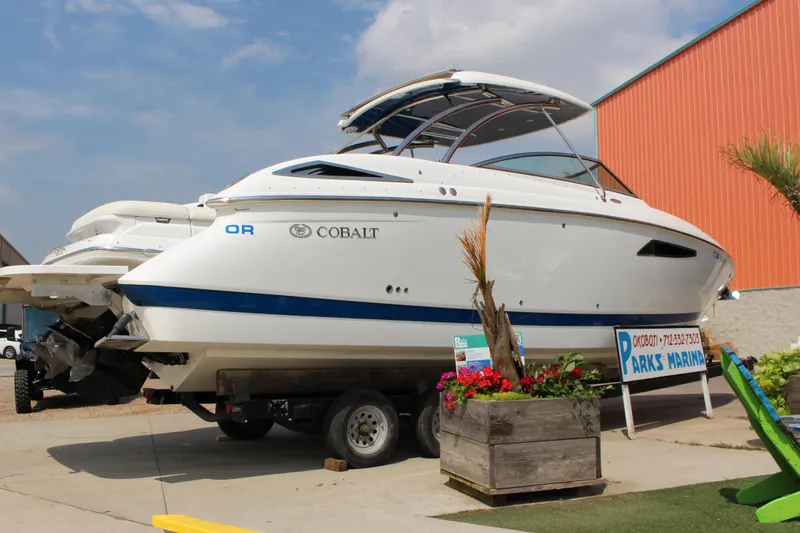 Slide: The Image of 2018 Cobalt R35 boat displayed at Parks Marina with vibrant flowers nearby. - 60