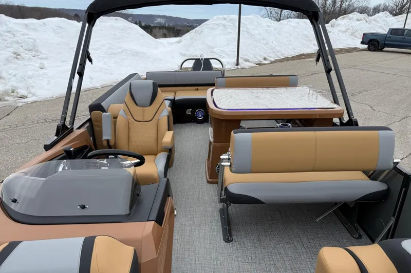 Slide: The Image of 2025 Tahoe 2785 boat interior with tan and gray seating, steering wheel, and table. - 12