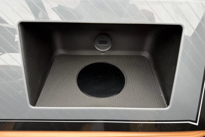 Slide: The Image of Storage compartment in 2025 Tahoe 2785, featuring a textured surface and circular plug. - 17