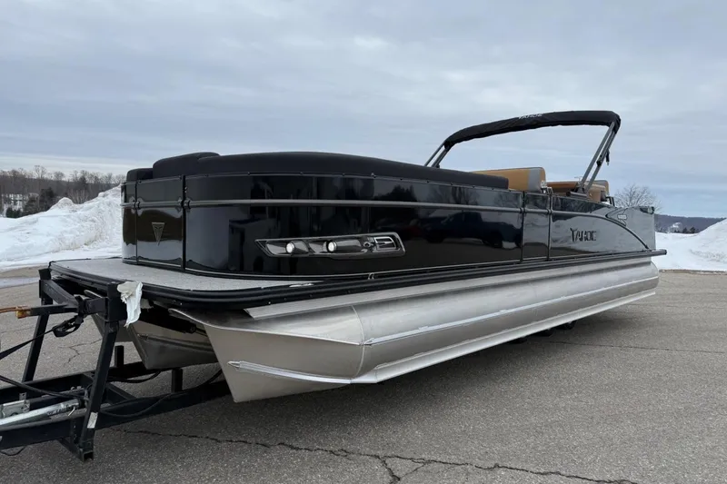 Slide: The Image of 2025 Tahoe 2785 pontoon boat on trailer, parked on snowy pavement. - 2