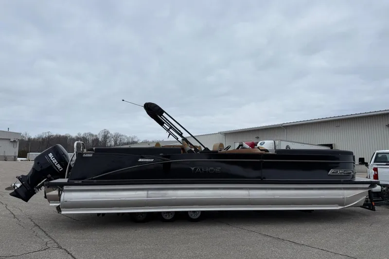 Slide: The Image of 2025 Tahoe 2785 pontoon boat with Suzuki outboard motor, parked outdoors. - 6