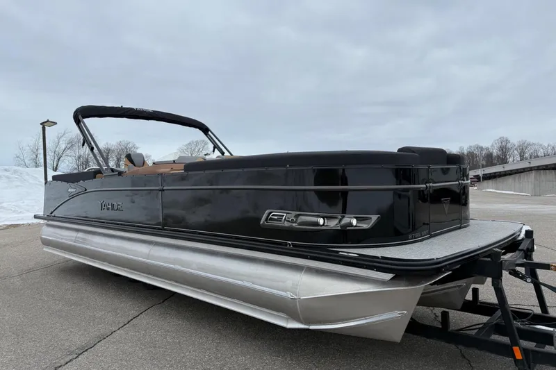 Slide: The Image of 2025 Tahoe 2785 pontoon boat with sleek black design on a trailer. - 7