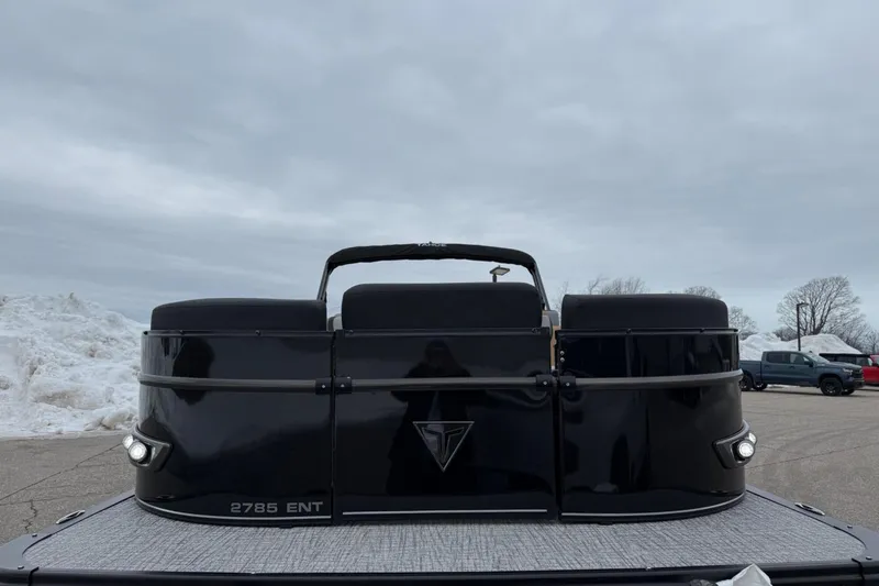 Slide: The Image of 2025 Tahoe 2785 boat, black exterior, parked on snowy pavement under cloudy sky. - 8