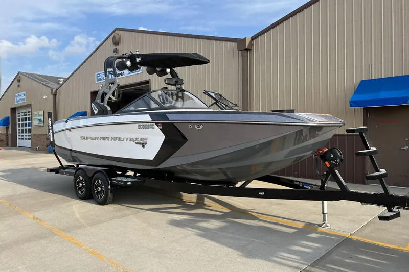The Image of 2018 Nautique Super Air Nautique G25 boat on trailer outside marina. - 1