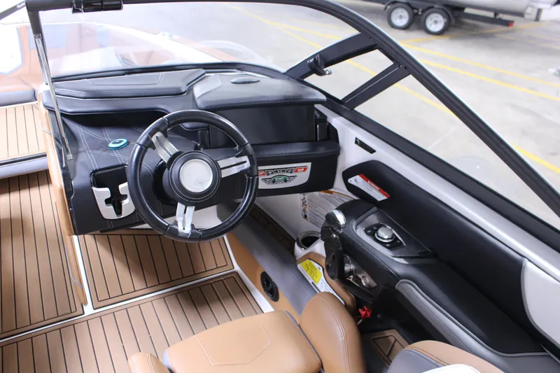 Slide: The Image of 2018 Nautique Super Air Nautique G25 boat interior with steering wheel and dashboard controls. - 4