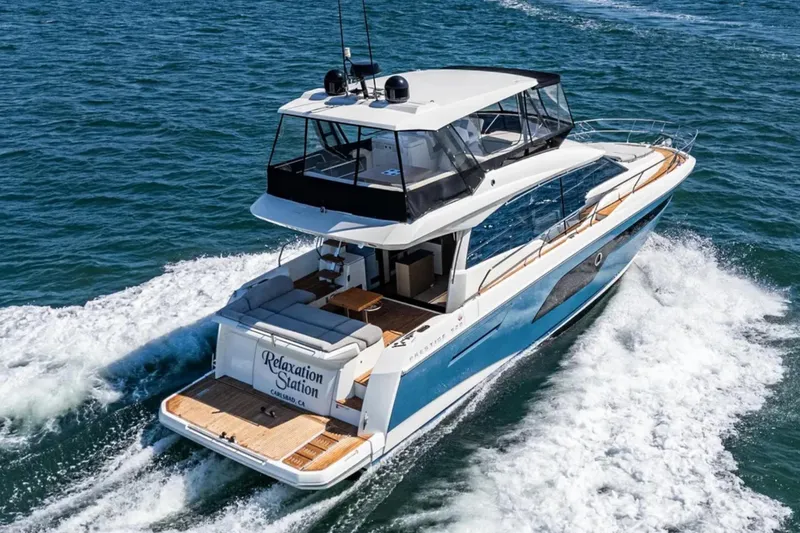 Slide: The Image of 2019 Prestige 520 yacht cruising on open water, named "Relaxation Station." - 30