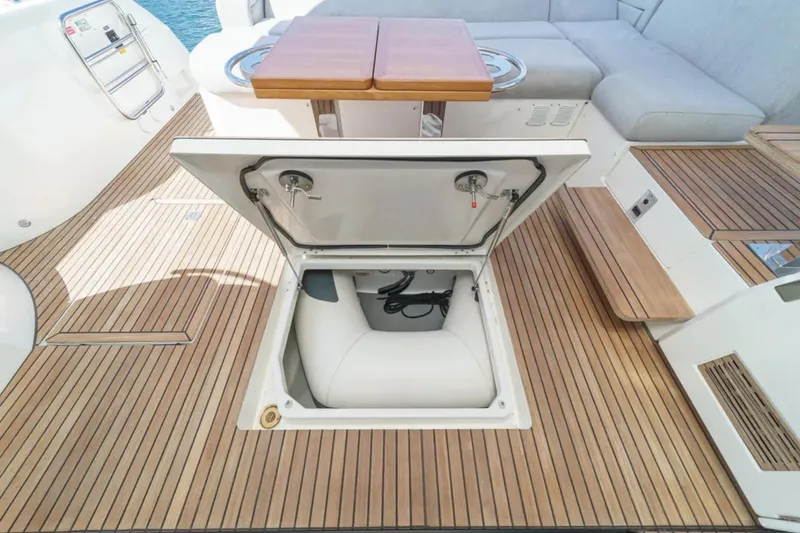 Slide: The Image of Open hatch on 2019 Prestige 520 yacht deck with wooden flooring and seating area. - 36