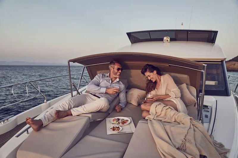 Slide: The Image of Manufacturer Provided Image: Couple relaxing on a 2019 Prestige 520 yacht, enjoying snacks and drinks. - 4