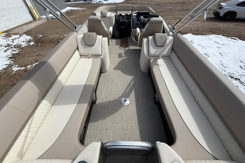Slide: The Image of 2025 Tahoe 2585 boat interior with beige seating and steering console. - 10