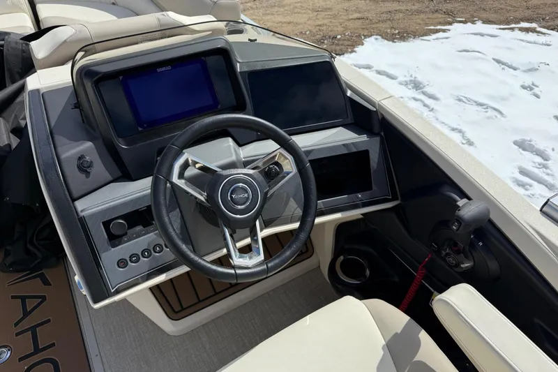 Slide: The Image of Steering console of 2025 Tahoe 2585 boat with modern controls and snowy background. - 17