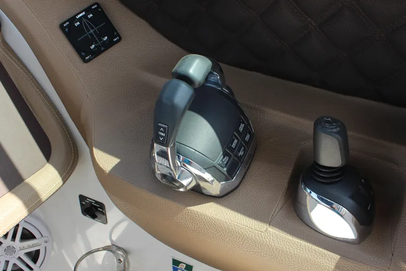 Slide: The Image of 2017 Cobalt R35 boat controls with joystick and throttle on brown leather panel. - 15