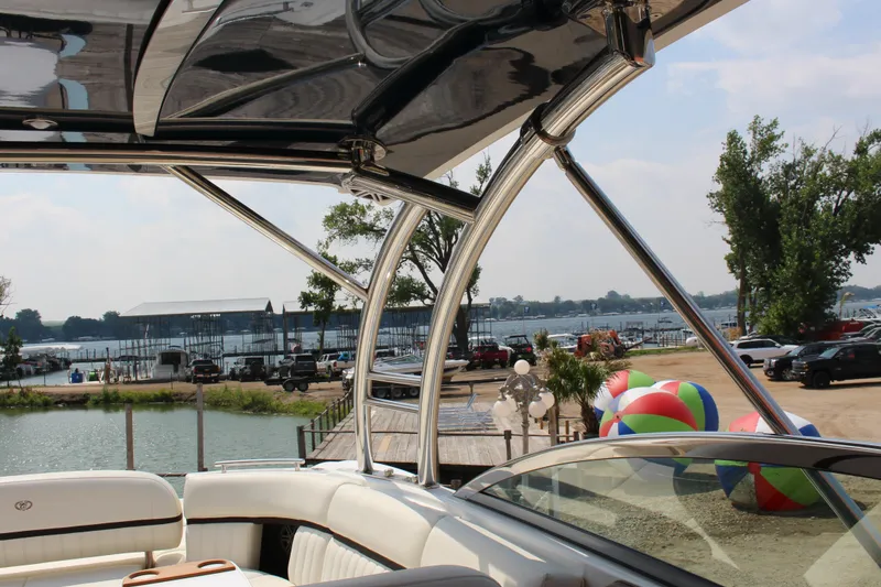 Slide: The Image of Cobalt R35 boat interior with lake view, colorful beach balls, and parked cars in the background. - 31