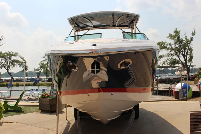 Slide: The Image of 2017 Cobalt R35 boat docked, front view, sunny day, trees in background. - 36