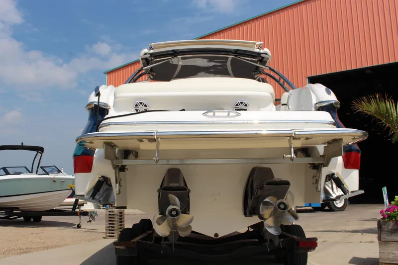 Slide: The Image of 2017 Cobalt R35 boat with dual propellers, parked near a red building under a blue sky. - 40