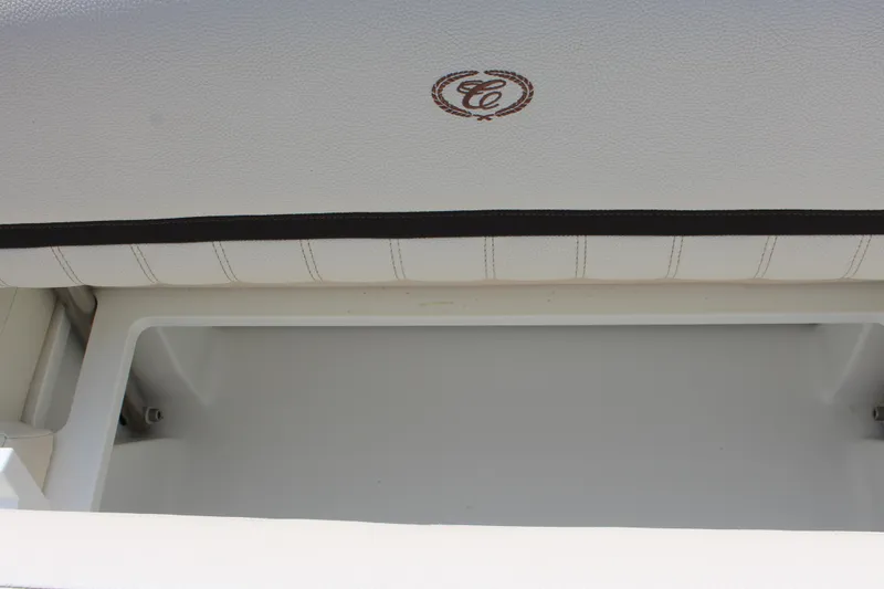 Slide: The Image of 2017 Cobalt R35 boat storage compartment with logo on white upholstery. - 53
