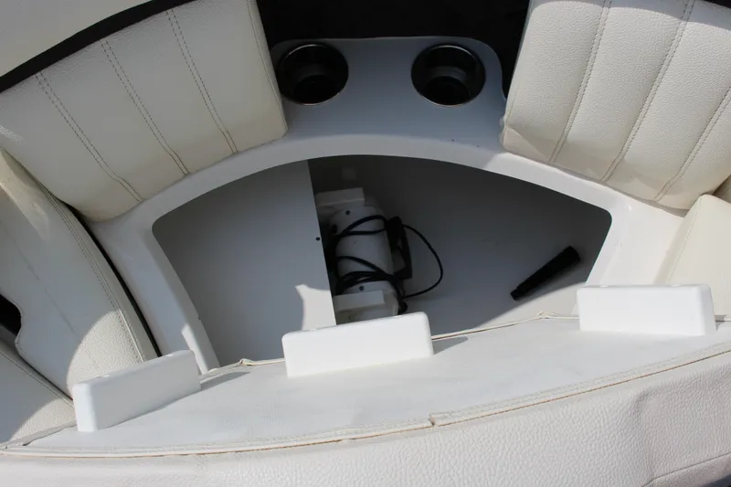 Slide: The Image of 2017 Cobalt R35 boat interior storage compartment with white seating and cup holders. - 54