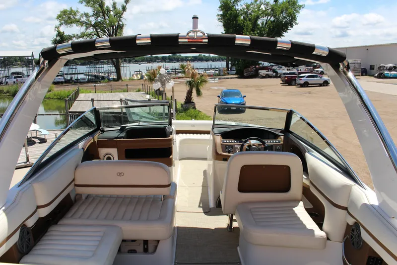 Slide: The Image of 2016 Cobalt R30 boat interior with seating, steering wheel, and dock view. - 10