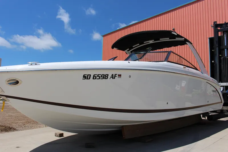 Slide: The Image of 2016 Cobalt R30 boat with canopy, docked under clear blue sky. - 2