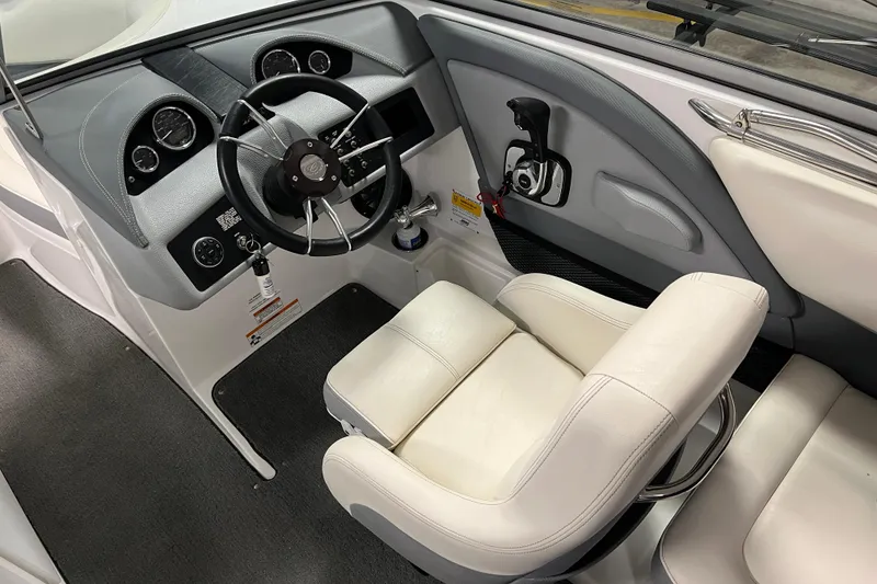 Slide: The Image of Interior of a 2015 Cobalt 200 boat, featuring a sleek steering wheel and white seating. - 3