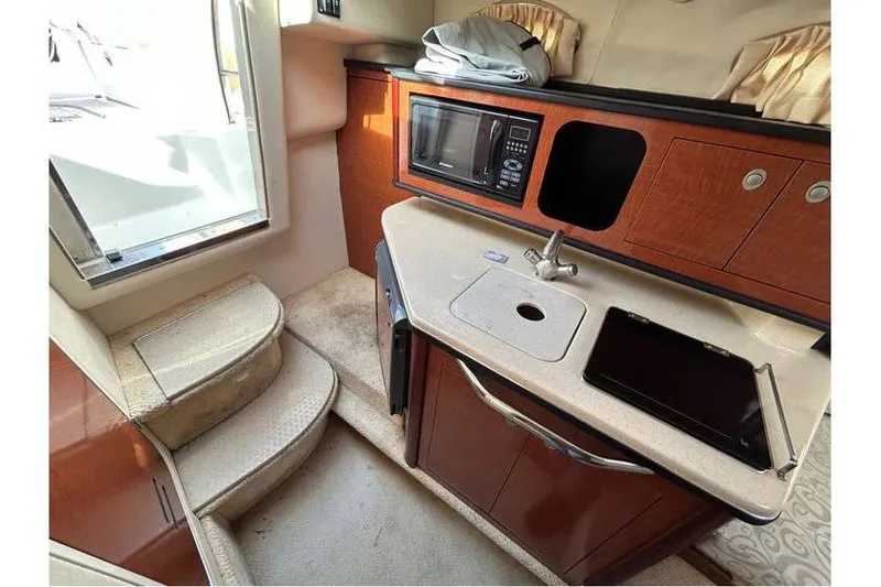 Slide: The Image of 2007 Sea Ray 270 Amberjack cabin interior with kitchenette, microwave, and stairs. - 11