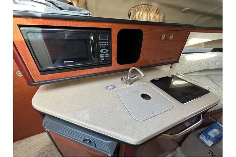 Slide: The Image of 2007 Sea Ray 270 Amberjack interior kitchen with microwave, sink, and countertop. - 15