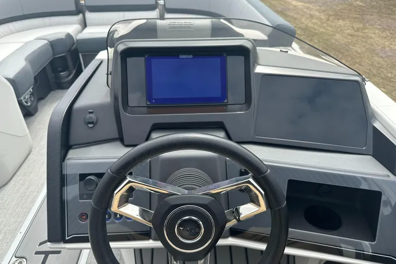 Slide: The Image of 2025 Tahoe 2585 boat dashboard with steering wheel and digital display. - 11