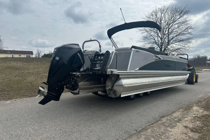 Slide: The Image of 2025 Tahoe 2585 pontoon boat with Mercury outboard motor on a road. - 5