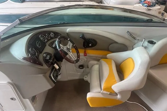 Slide: The Image of 2015 Crownline E6 boat interior with steering wheel and yellow-accented seating. - 1