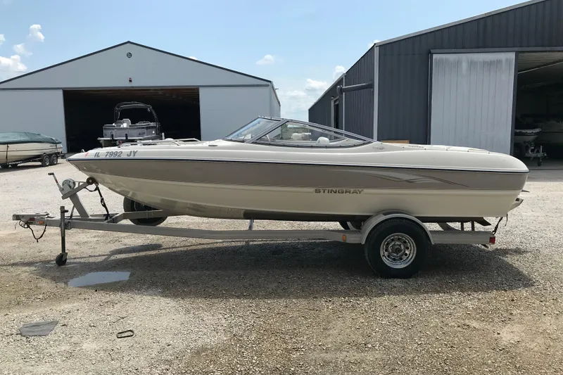 Slide: The Image of 2005 Stingray 195 LR boat on trailer, parked outside a storage facility. - 1