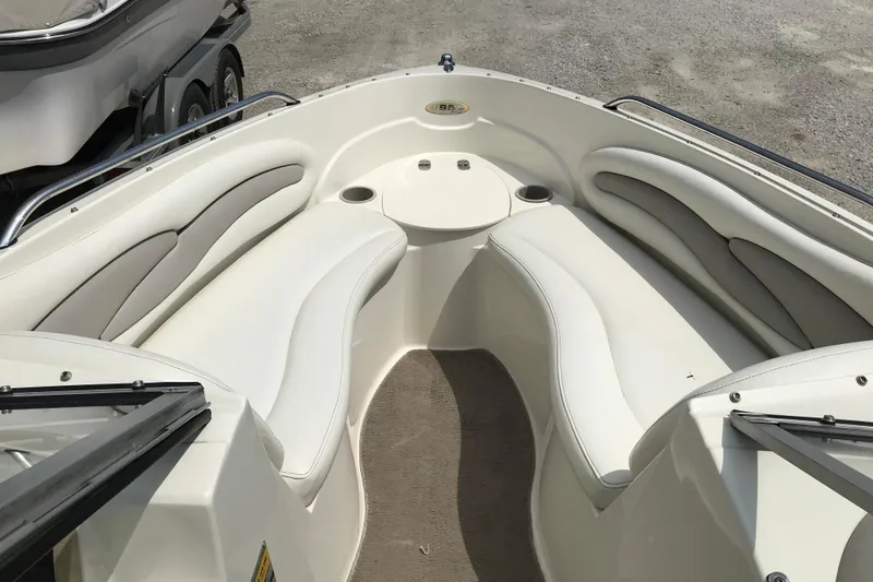 Slide: The Image of 2005 Stingray 195 LR boat interior with white cushioned seating and cup holders. - 11