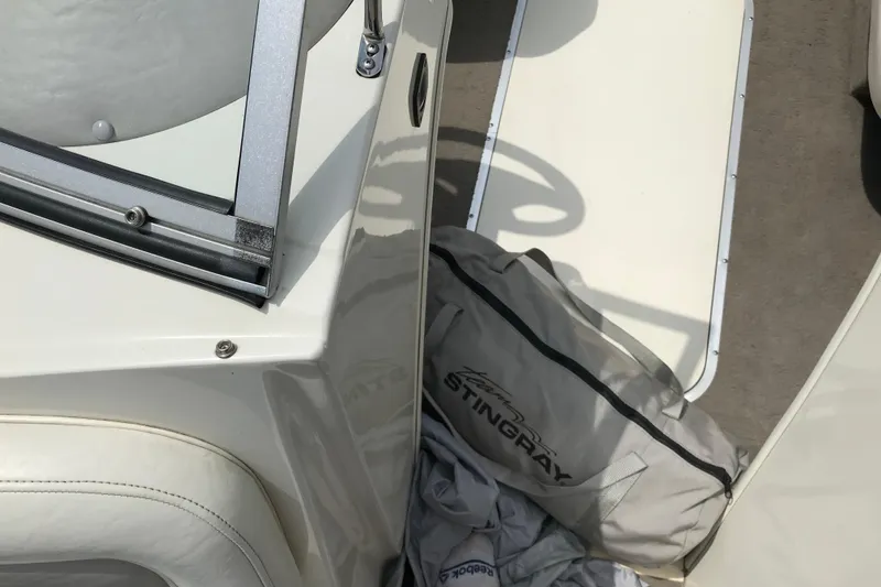Slide: The Image of 2005 Stingray 195 LR boat interior with branded bag and seating area. - 14