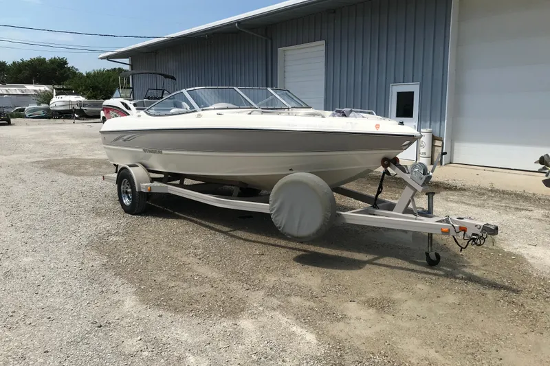 Slide: The Image of 2005 Stingray 195 LR boat on trailer outside a metal building. - 3