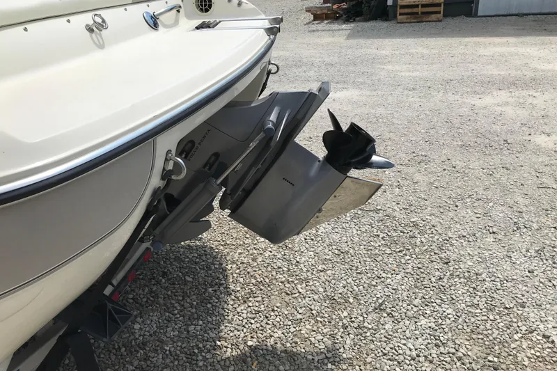 Slide: The Image of 2005 Stingray 195 LR boat with outboard motor on gravel surface. - 6