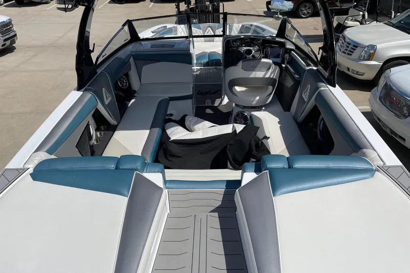 Slide: The Image of 2014 Tigé 23 boat interior with blue and white seating, steering wheel, and dashboard. - 3