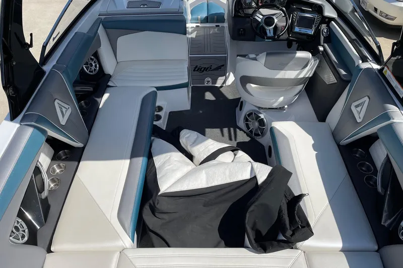 Slide: The Image of 2014 Tigé 23 boat interior with white seating, steering wheel, and speakers. - 5