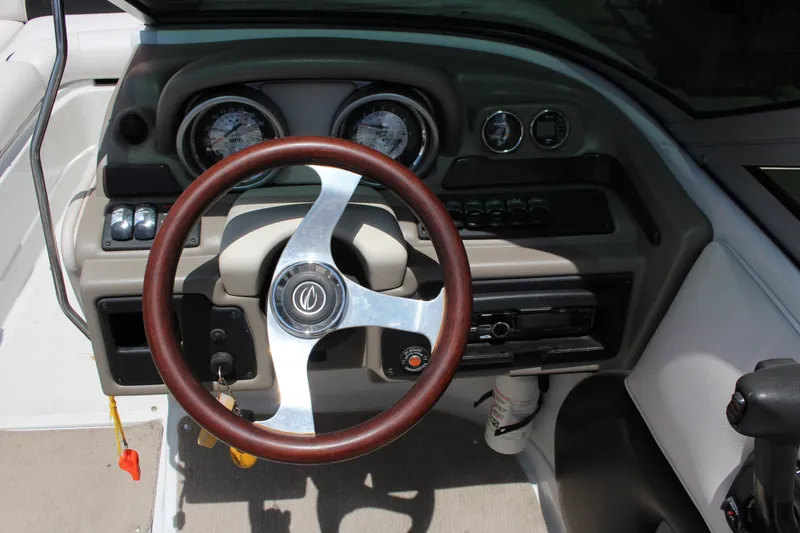 Slide: The Image of Steering wheel and dashboard of a 2013 Crownline E1 boat, featuring gauges and controls. - 5