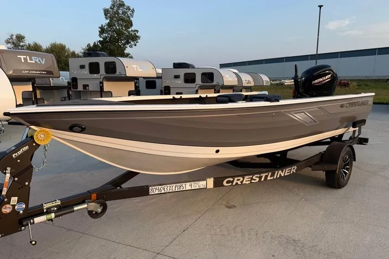 Slide: The Image of 2026 Crestliner 1850 Pro Tiller boat on trailer, parked near RVs. - 2