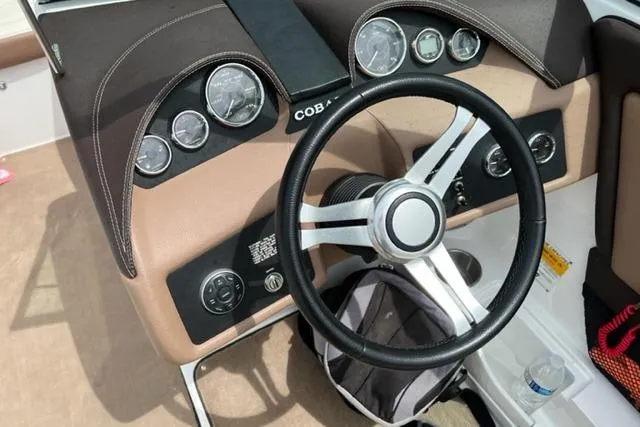 Slide: The Image of Steering wheel and dashboard of a 2011 Cobalt 200 boat with gauges and controls. - 3