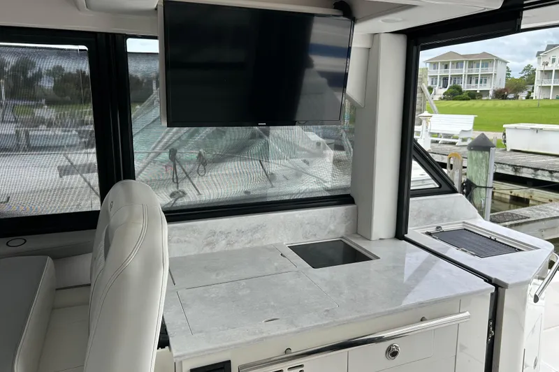 Slide: The Image of Interior of 2022 Regal 36 XO yacht with modern kitchen and TV setup. - 10