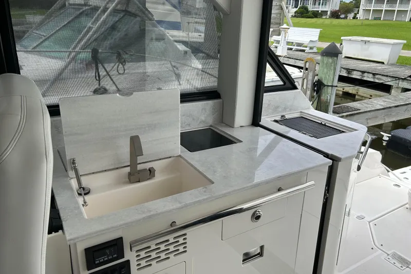 Slide: The Image of 2022 Regal 36 XO yacht interior with modern kitchenette and sleek design. - 11