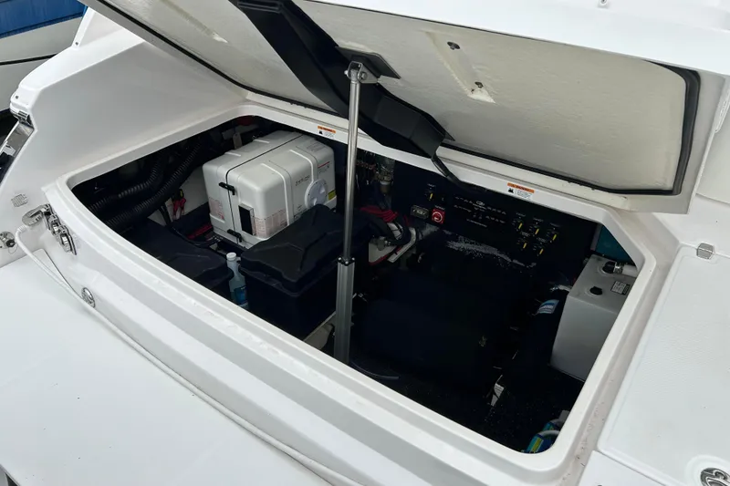 Slide: The Image of Open engine compartment of 2022 Regal 36 XO boat, showcasing internal components and storage. - 12