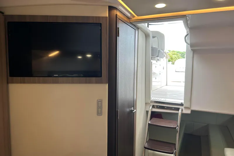 Slide: The Image of Interior of 2022 Regal 36 XO yacht with TV, door, and ladder to deck. - 16