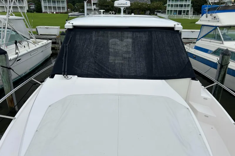 Slide: The Image of 2022 Regal 36 XO boat docked with covered windshield and deck. - 21