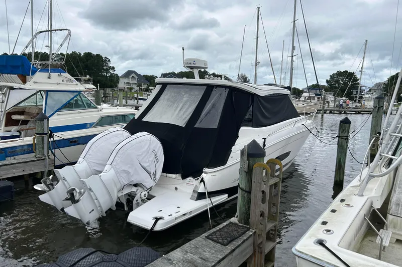 Slide: The Image of 2022 Regal 36 XO boat docked at marina with covered outboard engines. - 3